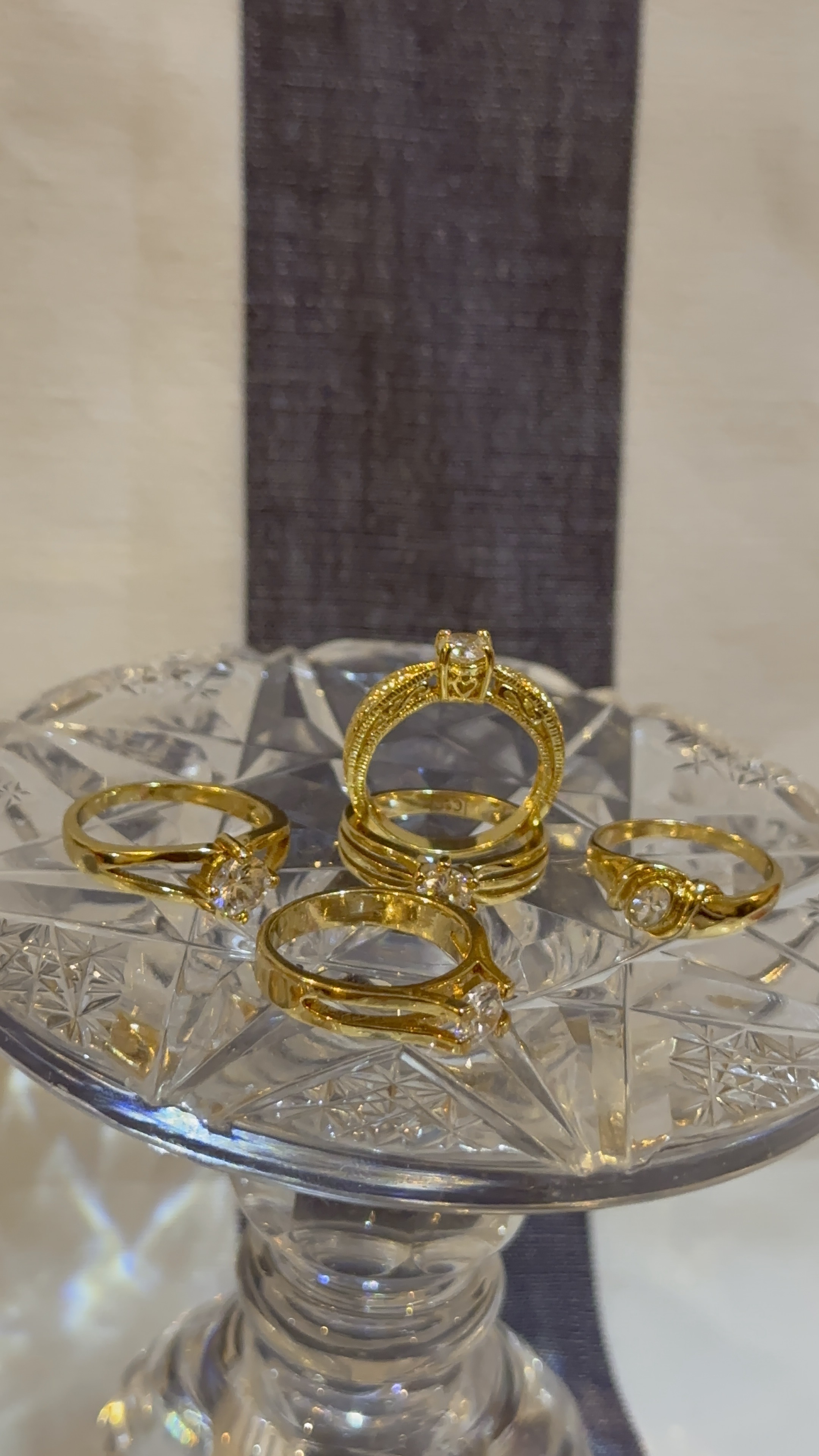 Crown and Gold ring collection on crystal pedestal